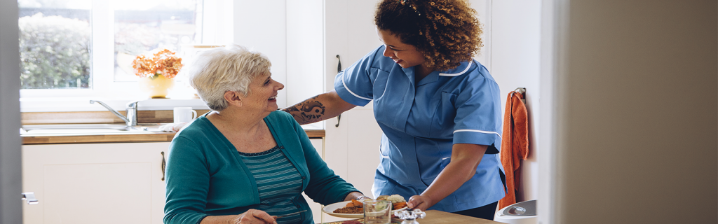 Social Care Worker serving dinner