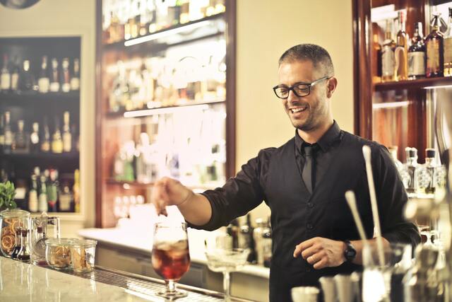 bartender making a drink at a bar