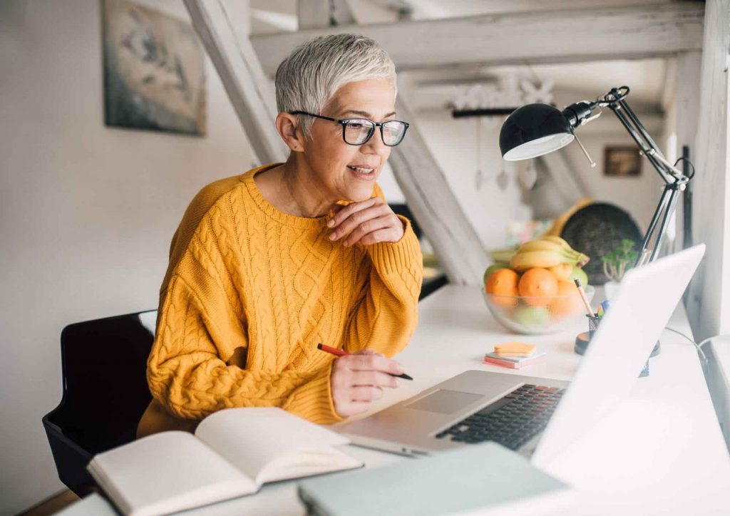 An image of an older woman working from home